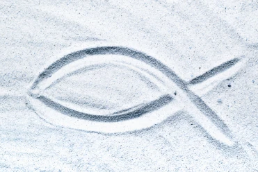 Christian fish symbol in beach sand